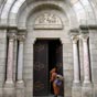 Le portail de l’église Saint-Étienne avec un pèlerin entrant.